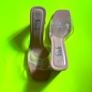 Brand new, never worn sandals, with a thin heel, and a clear strap.